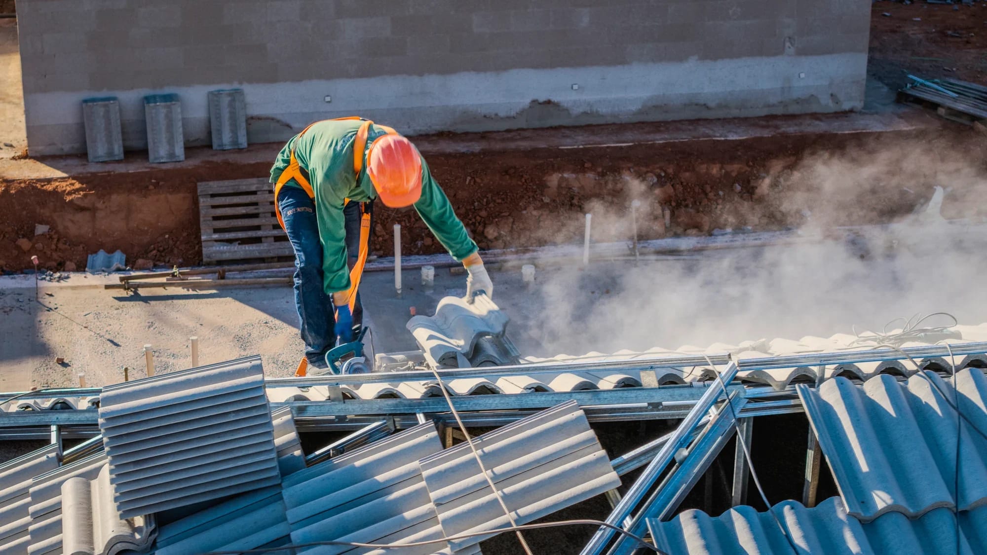 Equipe instalando telhas sobre a estrutura metálica